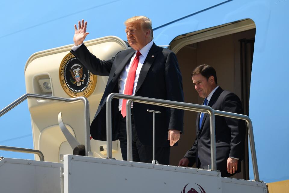 President Donald Trump and Arizona Governor Doug Ducey disembark from Air Force One in June. Ducey has joined in with Trump's dismissive stance on the virus. (Photo: SAUL LOEB via Getty Images)