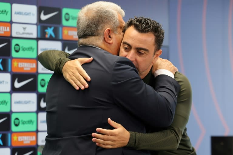 El presidente del FC Barcelona Joan Laporta (izquierda) abraza al técnico Xavi Hernández tras la conferencia de prensa ofrecida ambos para explicar la continuidad del entrenador, en las instalaciones del club en Sant Joan Despí, cerca de Barcelona, el 25 deabril de 2024 (LLUIS GENE)