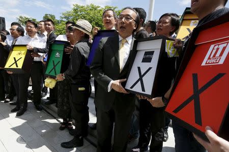 Pro-democracy lawmakers carrying signs symbolizing veto to a Beijing- backed electoral reform, while protesting outside Legislative Council in Hong Kong, China June 17, 2015. REUTERS/Bobby Yip