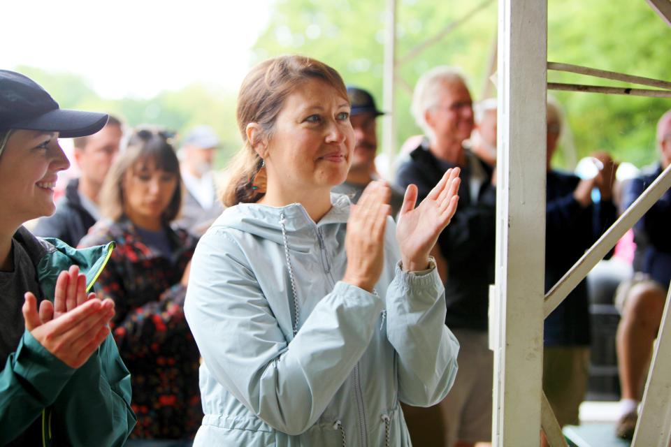 Ozark Greenways Executive Director Mary Kromrey applauds ahead of a ribbon cutting ceremony for Dirt 66 July 30, 2022.