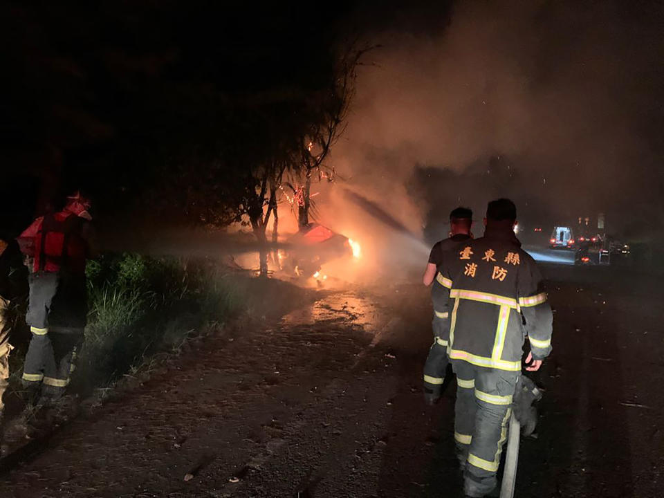 台東市人工湖旁堤防道路往台東大橋方向27日深夜傳出一輛自小客車火警，消防人員到現場時小客車已全面燃燒，緊急拉水線滅火。（中央社／台東縣消防局提供）