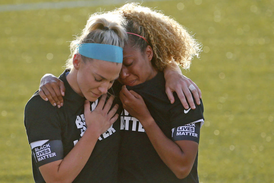 Chicago Red Stars' Julie Ertz, left, holds Casey Short after players for their team knelt during the national anthem before an NWSL Challenge Cup soccer match against the Washington Spirit at Zions Bank Stadium, Saturday, June 27, 2020, in Herriman, Utah. (AP Photo/Rick Bowmer)