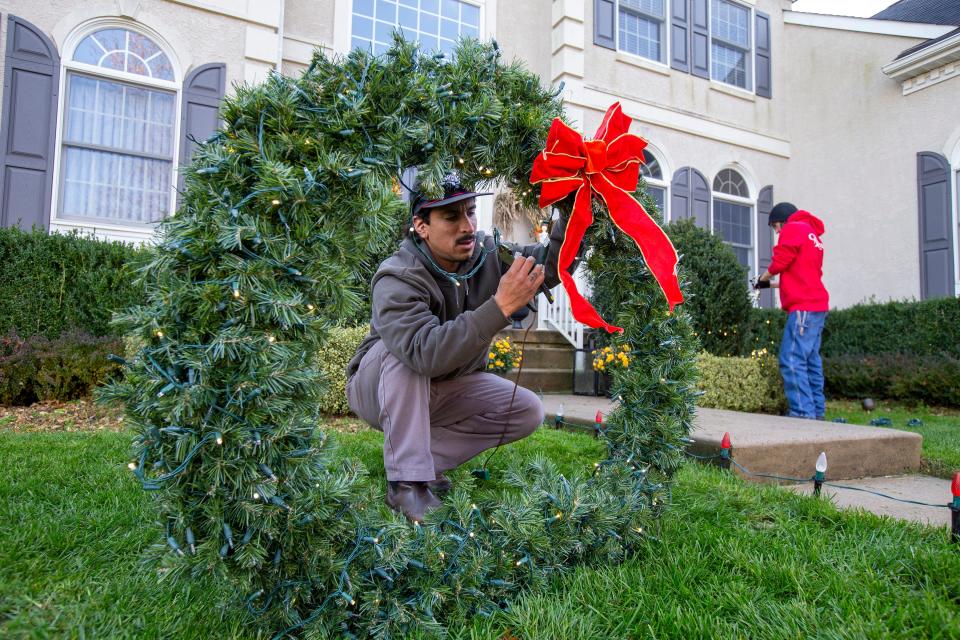 Danny Oquendo of Neptune, a foreman at Christmas Decor by Cowleys, a Howell company that installs Christmas decorations, decorates a home for the holidays in Tinton Falls, NJ Thursday, November 18, 2021.