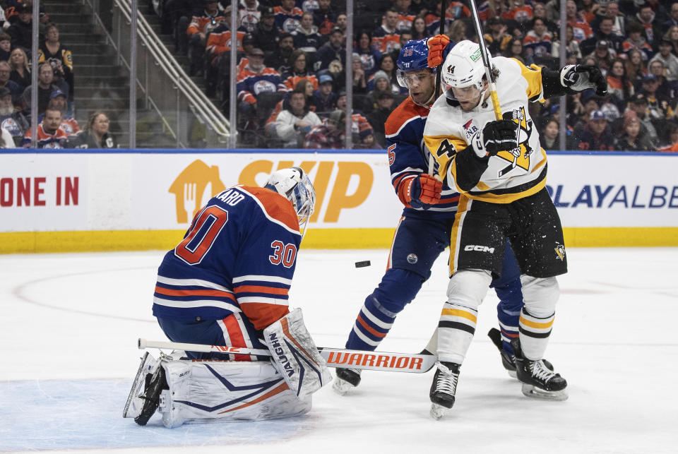 Pittsburg Penguins' Johnny Gruden (44) and Edmonton Oilers' Darnell Nurse (25) battle in front as goalie Calvin Pickard (30) makes the save during the first period of an NHL hockey game in Edmonton, Alberta, on Sunday, March 3, 2024. (Jason Franson/The Canadian Press via AP)