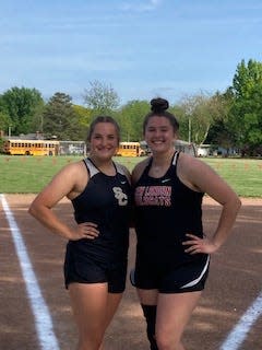 South Central's Claire Osborn and New London's Kaitlyn Gum pose for a picture after qualifying for the Division III state track and field meet in the shot put.