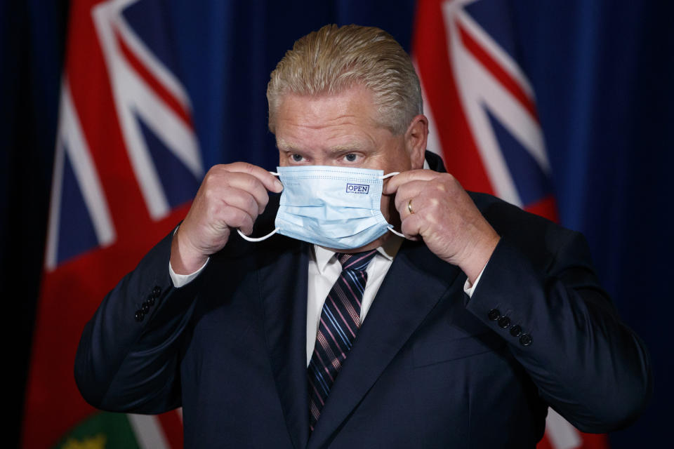 Ontario Premier Doug Ford puts his mask back on after speaking during a press conference at Queens Park in Toronto. (Credit: Cole Burston/The Canadian Press)