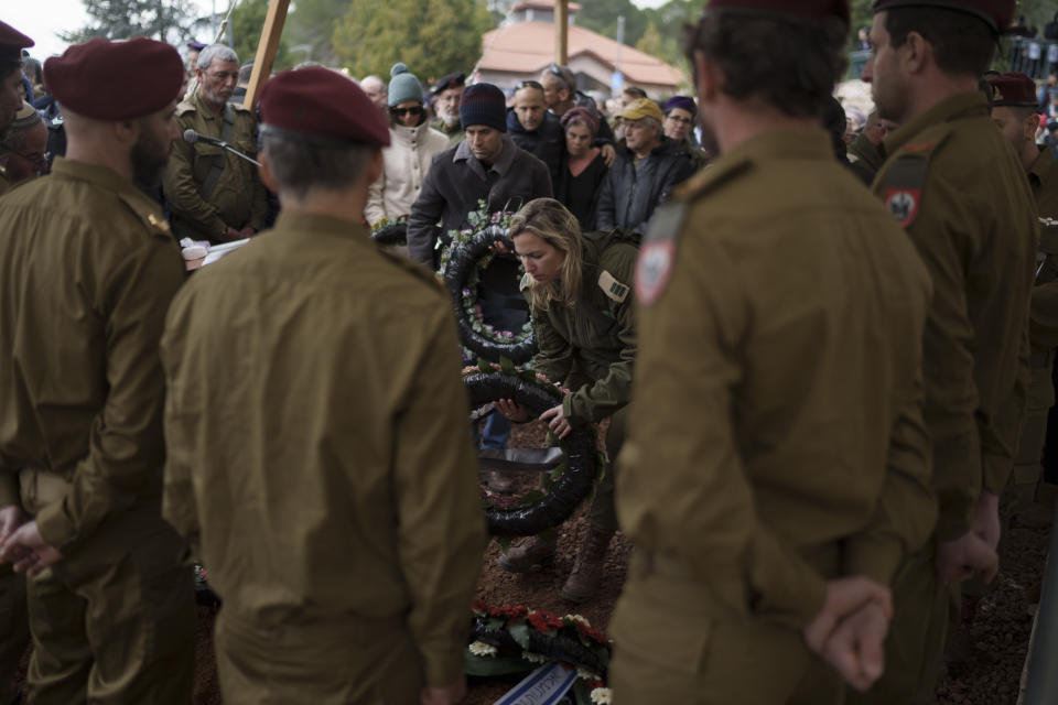 A member of Israeli forces lays a wreath of flowers over the grave of Israeli reservist warrant officer Yuval Nir during his funeral at a cemetery in the West Bank settlement of Kfar Etzion, Israel, Wednesday, Jan. 31, 2024. Nir, 43, was killed during Israel's ground operation in the Gaza Strip, where the Israeli army has been battling Palestinian militants in the war ignited by Hamas' Oct. 7 attack into Israel. (AP Photo/Leo Correa)