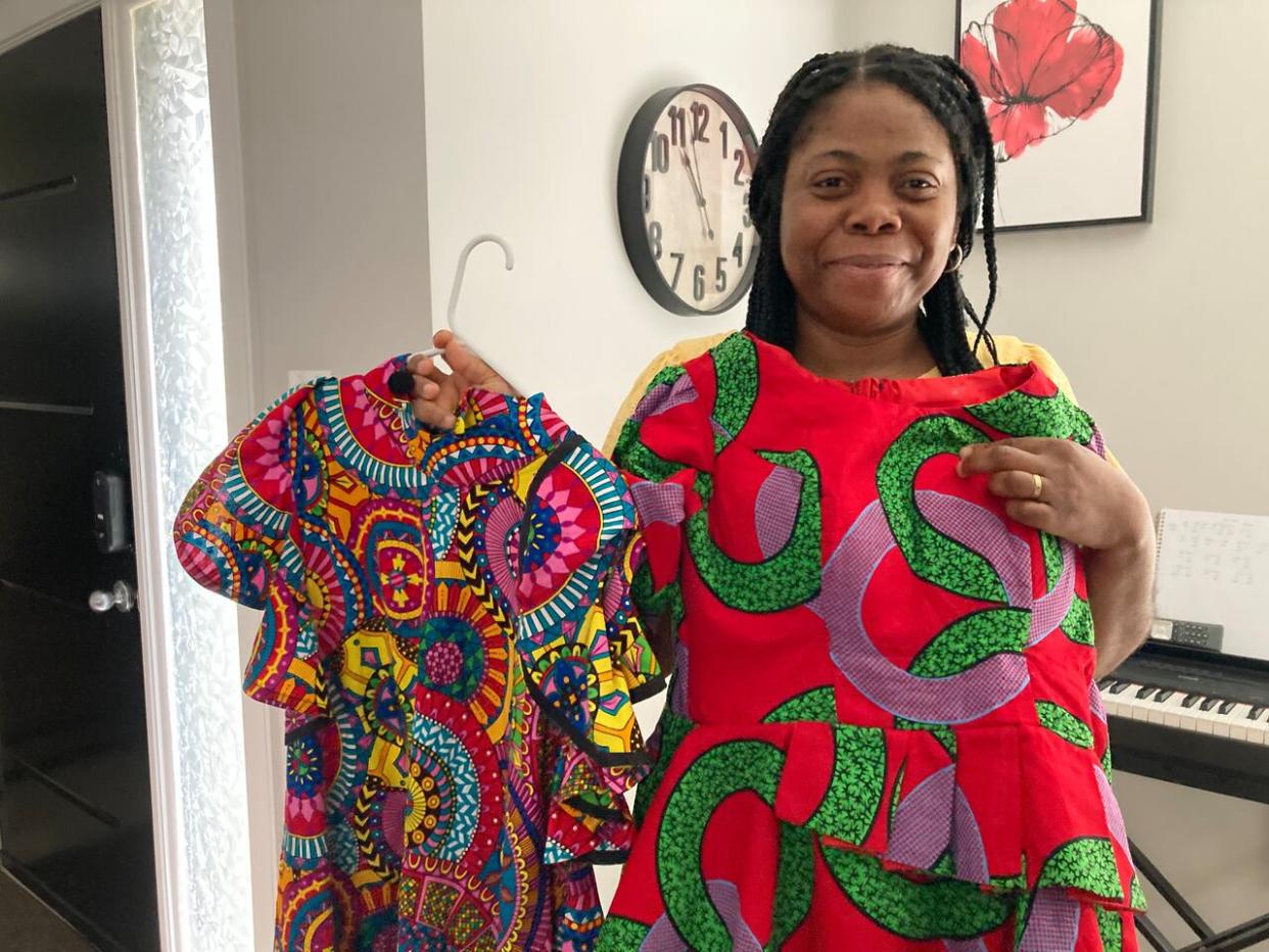 Charity Okposio displays colourful outfits made from traditional Ankara fabric. Family members, who came from Nigeria six years ago, wear the clothes as one way to keep ties to their culture.  (Mariam Mesbah/CBC News - image credit)