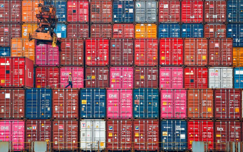 FILE PHOTO: A worker walks on stacks of containers at the Tanjung Priok port in Jakarta