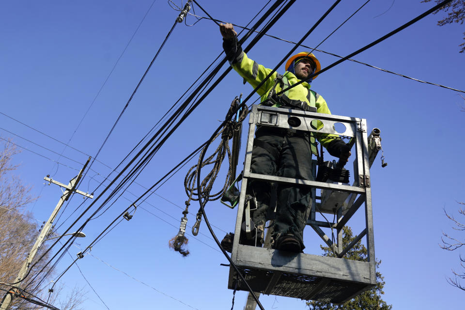 A utility worker works on lines in Detroit, Tuesday, Feb. 28, 2023. A new storm teeming with freezing rain and strong winds socked Michigan on Monday, presenting a fresh challenge for crews that have been trying to restore electricity to thousands of customers who have been in the dark since ice snapped lines days ago. (AP Photo/Paul Sancya)