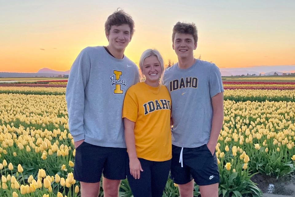 In this photo provided by Stacy Chapin, triplets Ethan, Maizie and Hunter Chapin pose in front of a tulip field in La Conner, Washington.