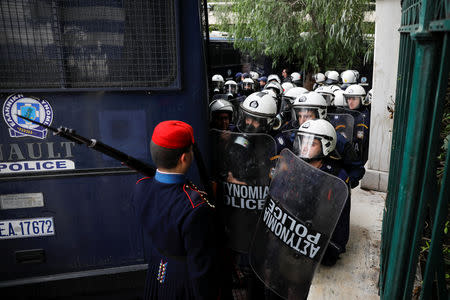 A Greek Presidential Guard returning to his barracks following his sentry duty, stands in front of riot police officers blocking the road leading to the Prime Minister's office during a demonstration of Greek school teachers against government plans to change hiring procedures in the public sector in Athens, Greece, January 11, 2019. REUTERS/Alkis Konstantinidis