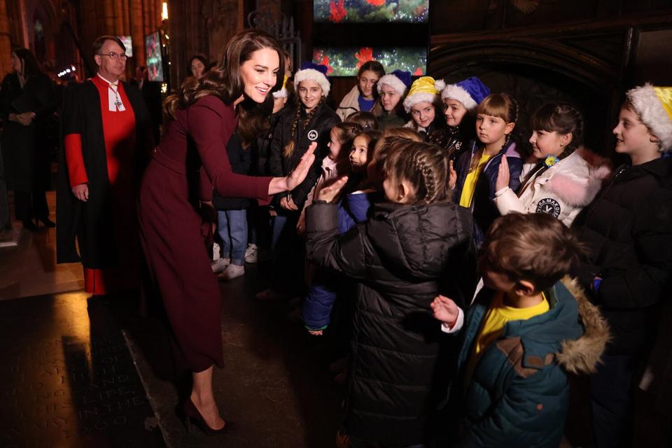 Catherine, Princess of Wales greets children with a high five at the 'Together at Christmas' Carol Service at Westminster Abbey