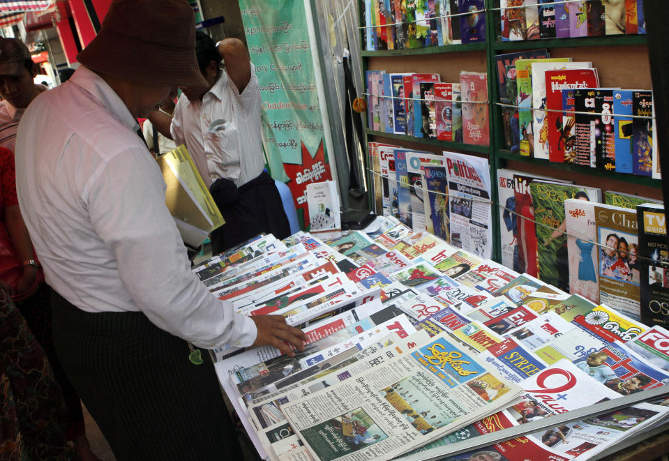 In this March 12, 2014 photo, a man checks to buy a copy among local weekly news journals and daily newspapers at a roadside shop in Yangon, Myanmar. One year after publishers and editors took advantage of a decision by the country's nominally civilian government to lift a half-century-old ban on private dailies, the feeling of euphoria is fading. The struggle to compete with state-owned papers for advertisers and circulation have made it impossible for many to forge on. Golden Fresh Land, published its last edition Wednesday, March 12. It is the first well-known private daily to fold, but 11 others that are still publishing also appear to be struggling. (AP Photo/Khin Maung Win)