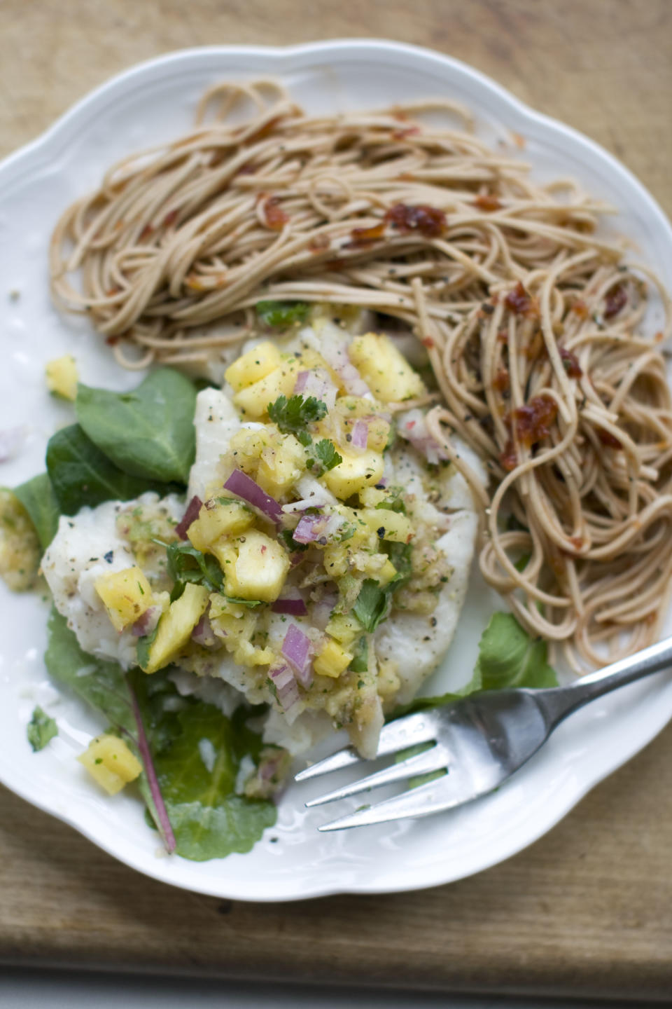 This Dec. 2, 2013 photo shows baked haddock with pineapple mint salsa in Concord, N.H. Baked white fish is a fast and healthy way to get dinner on the table. The secret to getting a good tasting baked white fish, without adding tons of fat and calories or rendering it a tasteless hunk of protein, is all in how you dress it. (AP Photo/Matthew Mead)
