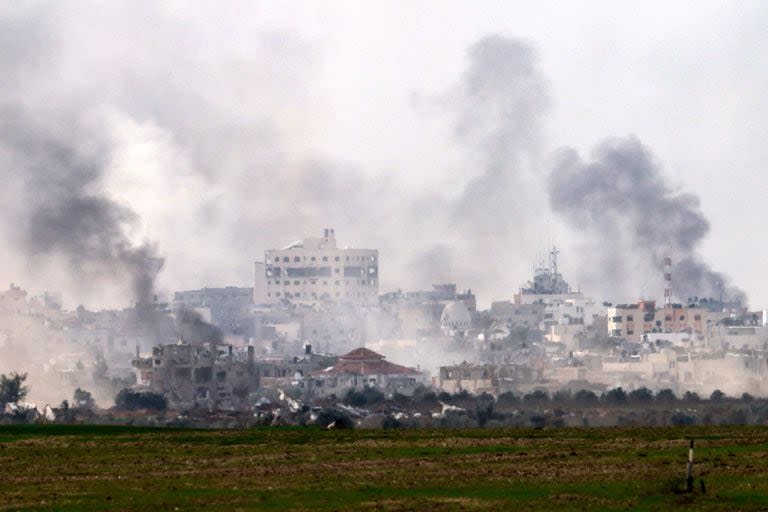 Una fotografía tomada desde el sur de Israel, cerca de la frontera con la Franja de Gaza, el 10 de diciembre de 2023, muestra humo elevándose sobre los edificios durante los bombardeos israelíes en Khan Yunis, en medio de batallas en curso con el grupo militante palestino Hamas. Las fuerzas israelíes avanzaron hacia el sur de Gaza el 10 de diciembre, donde cientos de miles de civiles han huido en busca de refugio de los bombardeos y los intensos combates con los militantes de Hamas.