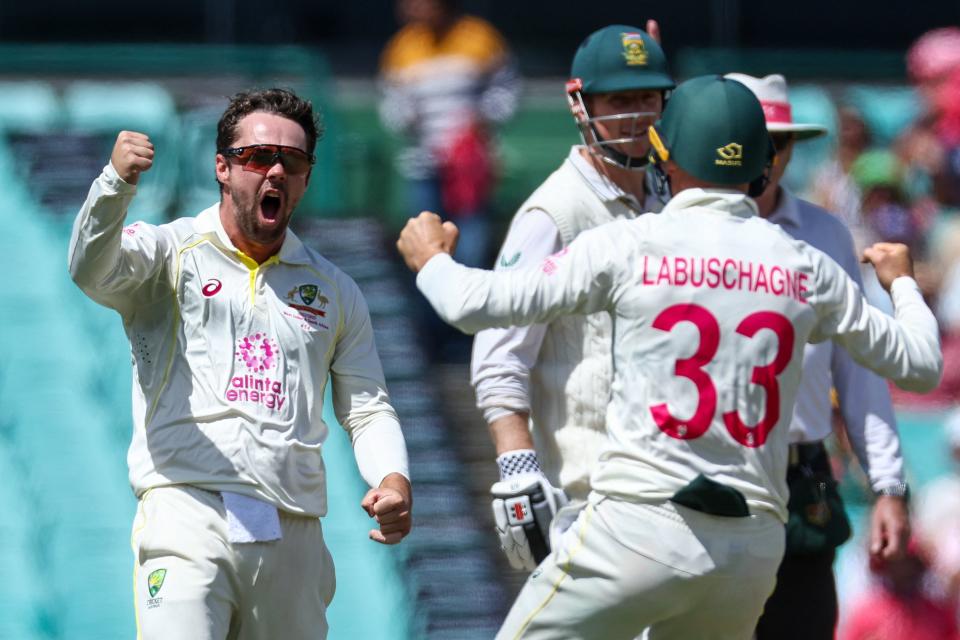 Travis Head (pictured left) celebrates taking a wicket.