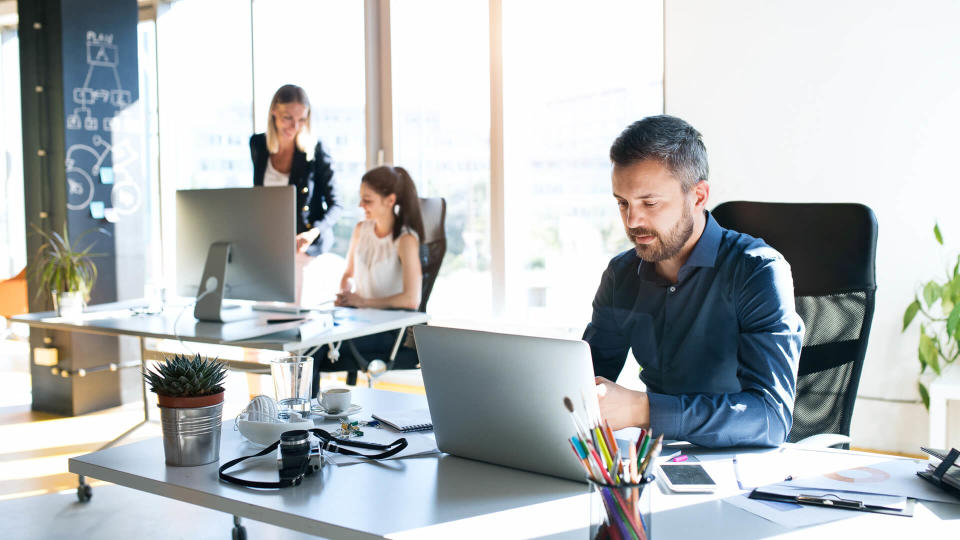 Three business people in the workplace.