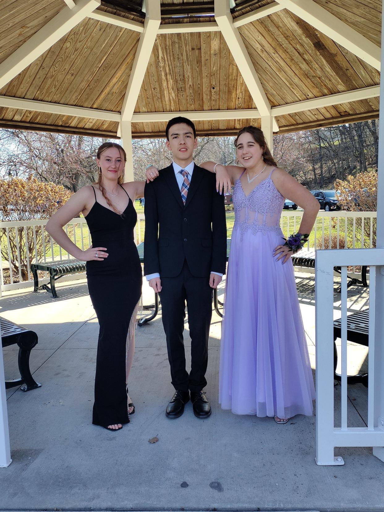 Aubrey Heinz (left), Josiah Reeves (center) and Bailey Piepenhagen pose for a photo at a pavilion before their prom on April 13 in Appleton.