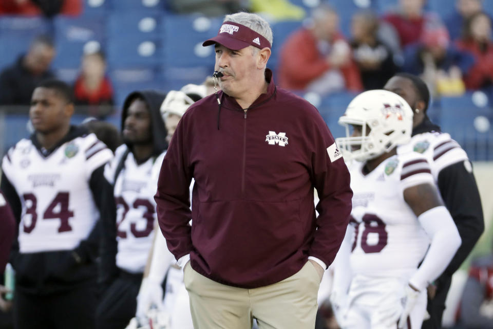 FILE - In this Dec. 30, 2019, file photo, Mississippi State head coach Joe Moorhead watches as players warm up before the Music City Bowl NCAA college football game against Louisville, in Nashville, Tenn. Two people with knowledge of the situation say Mississippi State has fired coach Joe Moorhead after just two seasons. They spoke to The Associated Press on condition of anonymity because an announcement had not yet been made by the school. A meeting was scheduled Friday, Jan. 3, 2020, with Moorhead and athletic director John Cohen.(AP Photo/Mark Humphrey, File)