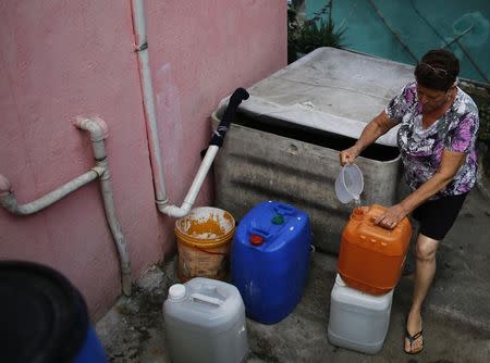 Nanceli, 61, fills a bucket with rainwater she collects from a water box, for use in the bathroom and to clean the floor of her house in Brasilandia slum, in Sao Paulo February 10, 2015. REUTERS/Nacho Doce