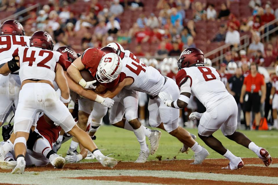 Stanford running back Casey Filkins, center, reaches the end zone for a touchdown against Colgate linebacker Evan Jones (45) and defensive back Marquis Cooper (8) during the fourth quarter of an NCAA college football game in Stanford, Calif., Saturday, Sept. 3, 2022. (AP Photo/Josie Lepe)