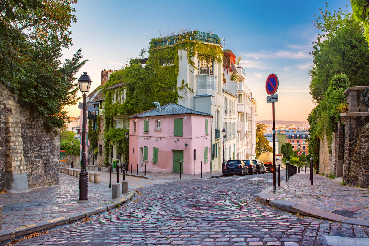 Cozy old street with pink house at the sunny sunrise, quarter Montmartre in Paris, France