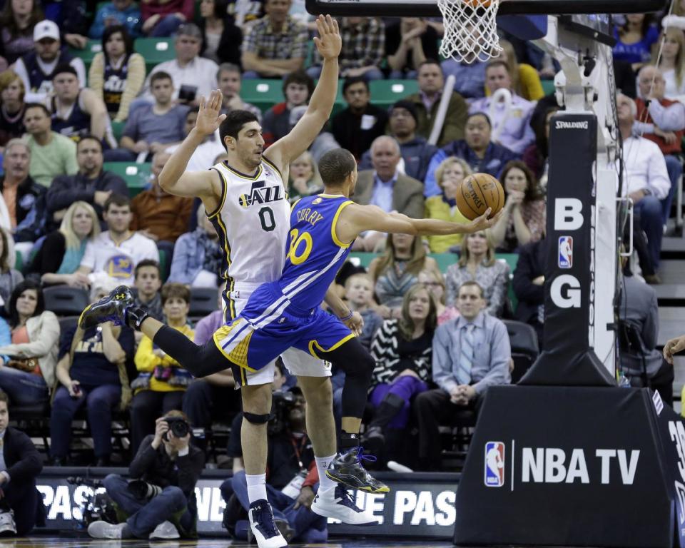 Golden State Warriors' Stephen Curry (30) lays the ball up as Utah Jazz's Enes Kanter (0) defends in the fourth quarter of an NBA basketball game Friday, Jan. 31, 2014, in Salt Lake City. Warriors won 95-90. (AP Photo/Rick Bowmer)