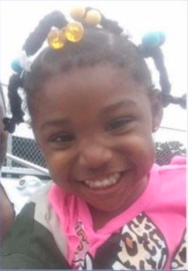 Kamille McKinney, the three-year-old girl smiling to the camera. 