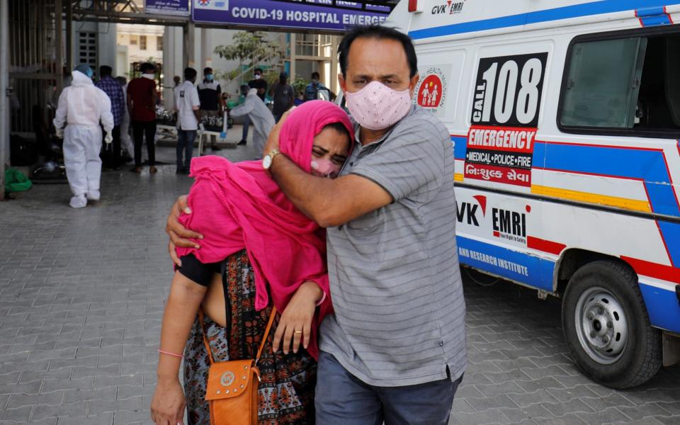 A woman is consoled after her relative died due to the coronavirus disease in Ahmedabad, India - Reuters