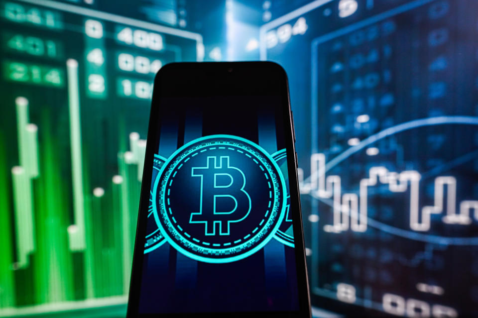 POLAND - 2023/07/14: In this photo illustration, a Bitcoin logo is displayed on a smartphone with Stock market graphics in the background. (Photo Illustration by Omar Marques/SOPA Images/LightRocket via Getty Images)