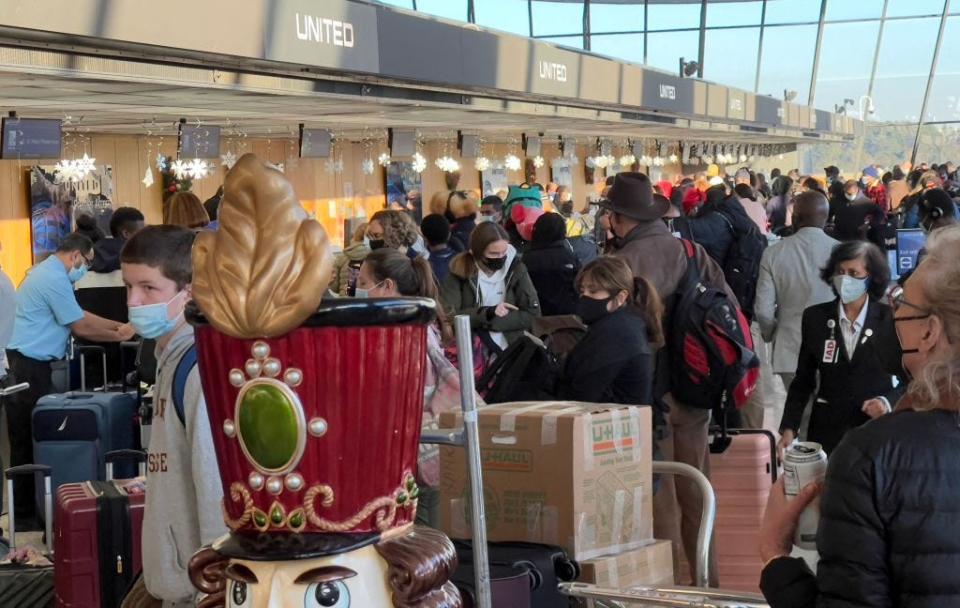 Holiday travelers transit through Dulles International Airport in Dulles, Virginia, on December 20, 2021.