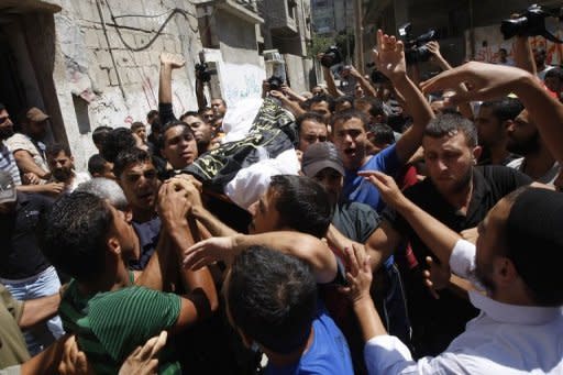 Palestinian mourners carry the body of Ismael al-Ismar, 34, during his funeral at Rafah town in the southern Gaza Strip. The Palestinian militant was killed by Israeli air strikes which prompted mortar fire into southern Israel just days after armed groups agreed to a temporary truce