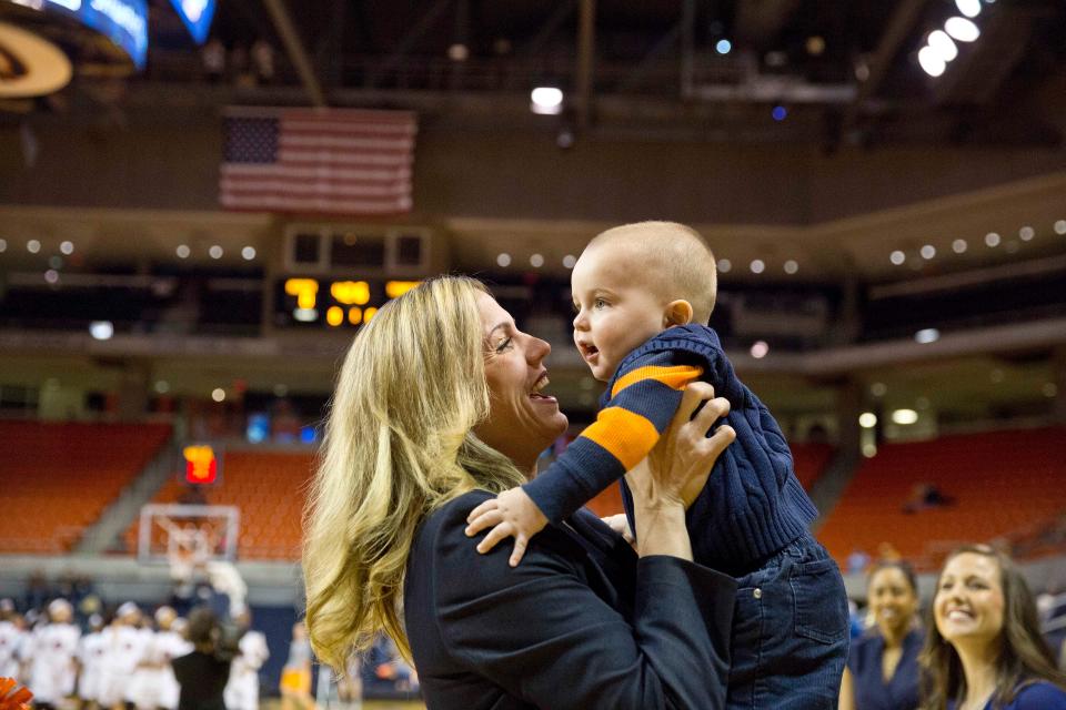 Stephanie Follett, special assistant to the Auburn head coach, kisses her son, Jack Follett before the beginning of an NCAA college basketball game Thursday, Jan. 15, 2015, in Auburn, Ala.