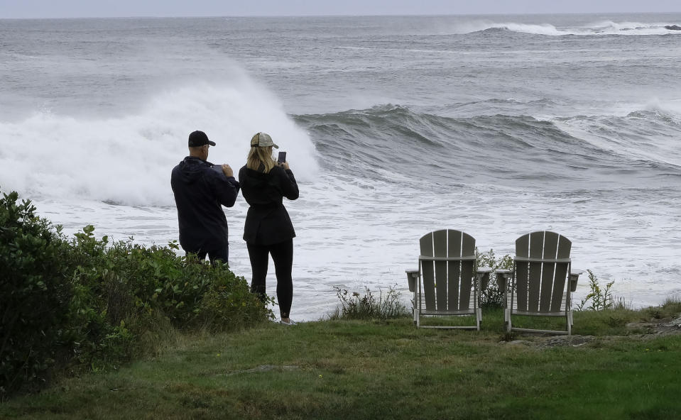 People watch rough surf and waves, remnants of Tropical Storm Lee, crash along the shore of Bailey Island, Maine, on Saturday, Sept 16, 2023. (AP Photo/Jim Gerberich)