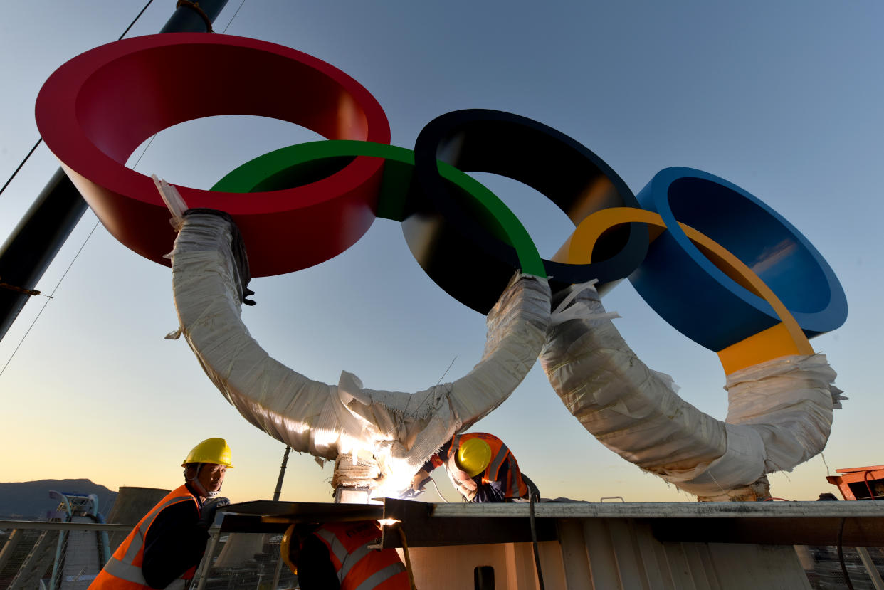 BEIJING, CHINA - OCTOBER 21: (Image taken with fisheye lens) Workers install Olympic rings at Shougang Park on October 20, 2021 in Beijing, China. The Big Air Shougang at Shougang Park will host the big air freestyle skiing and snowboarding competitions of the Beijing 2022 Winter Olympic Games. (Photo by Li Wenming/VCG via Getty Images)