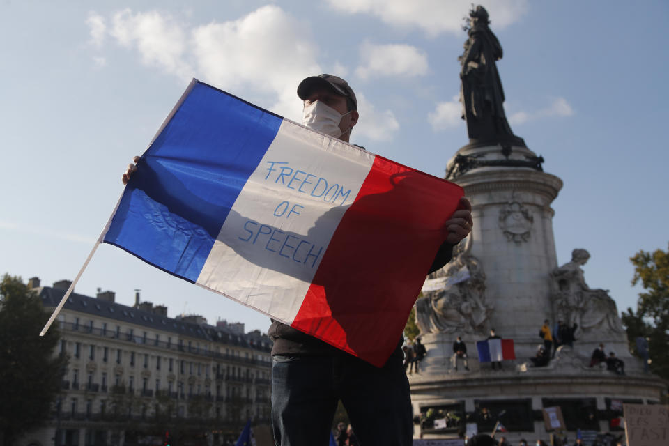 A demonstrator holds a French flag with the slogan "Freedom of Speech" during a demonstration Sunday Oct. 18, 2020 in Paris. Demonstrations around France have been called in support of freedom of speech and to pay tribute to a French history teacher who was beheaded near Paris after discussing caricatures of Islam's Prophet Muhammad with his class. Samuel Paty was beheaded on Friday by a 18-year-old Moscow-born Chechen refugee who was shot dead by police. (AP Photo/Michel Euler)