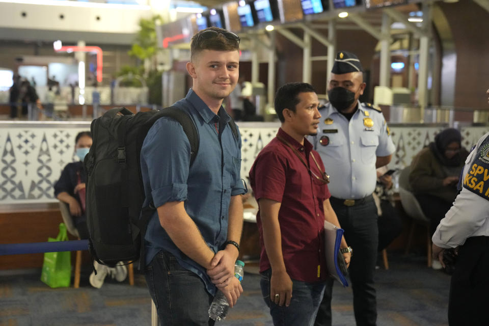 Australian national Bodhi Mani Risby-Jones from Queensland, left, accompanied by his lawyer Idris Marbawi, second left, and escorted by immigration officers wait for check in at Soekarno-Hatta International Airport in Tangerang, Indonesia, Saturday, June 10, 2023. Indonesia’s authorities are deporting an Australian surfer who apologized for attacking several people while drunk and naked in the deeply conservative province of Aceh. Bodhi Mani Risby-Jones was detained in late April on Simeulue Island, a surf resort, after police accused him of going on a drunken rampage that left a fisherman with serious injuries. (AP Photo/Dita Alangkara)