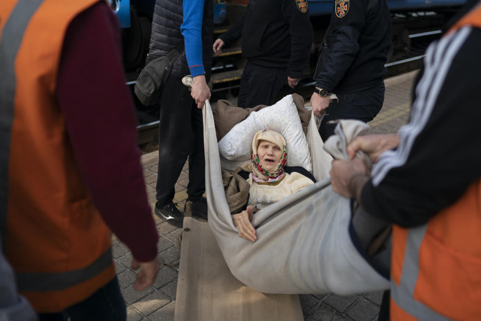 Klavidia, 91, is carried on an improvised stretcher as she boards a train, fleeing the war in Severodonetsk at a train station in Pokrovsk, Ukraine, Monday, April 25, 2022. Russia unleashed a string of attacks against Ukrainian rail and fuel installations Monday, striking crucial infrastructure far from the front line of its eastern offensive. (AP Photo/Leo Correa)