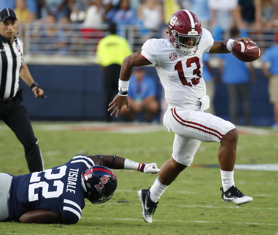Alabama quarterback Tua Tagovailoa (13) evades a tackle by Mississippi defensive end Tariqious Tisdale (22) during the first half of their NCAA college football game, Saturday, Sept. 15, 2018, in Oxford, Miss. (AP Photo/Rogelio V. Solis)