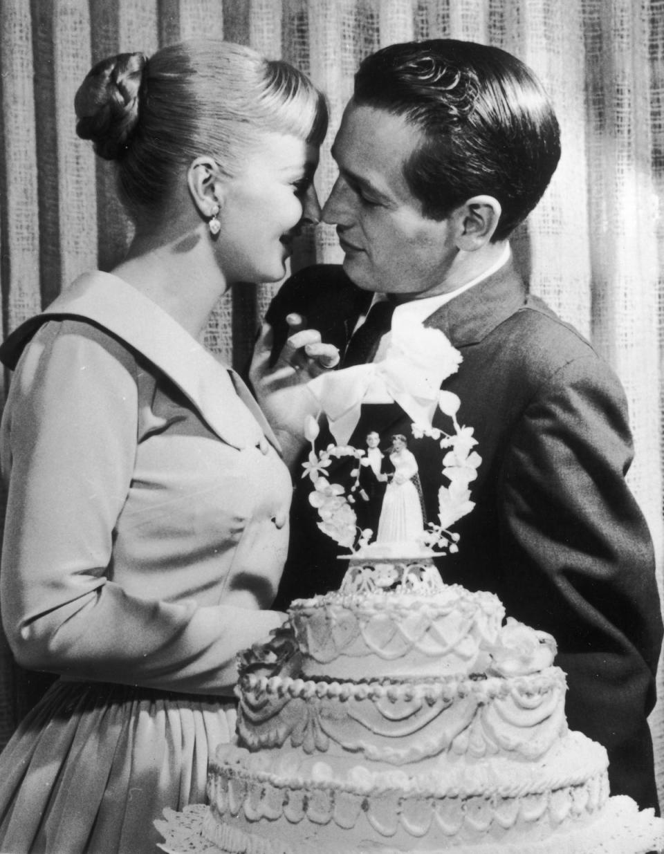 Paul Newman and Joanne Woodward kiss behind a wedding cake during their wedding reception at the El Rancho hotel-casino, Las Vegas (Getty Images)