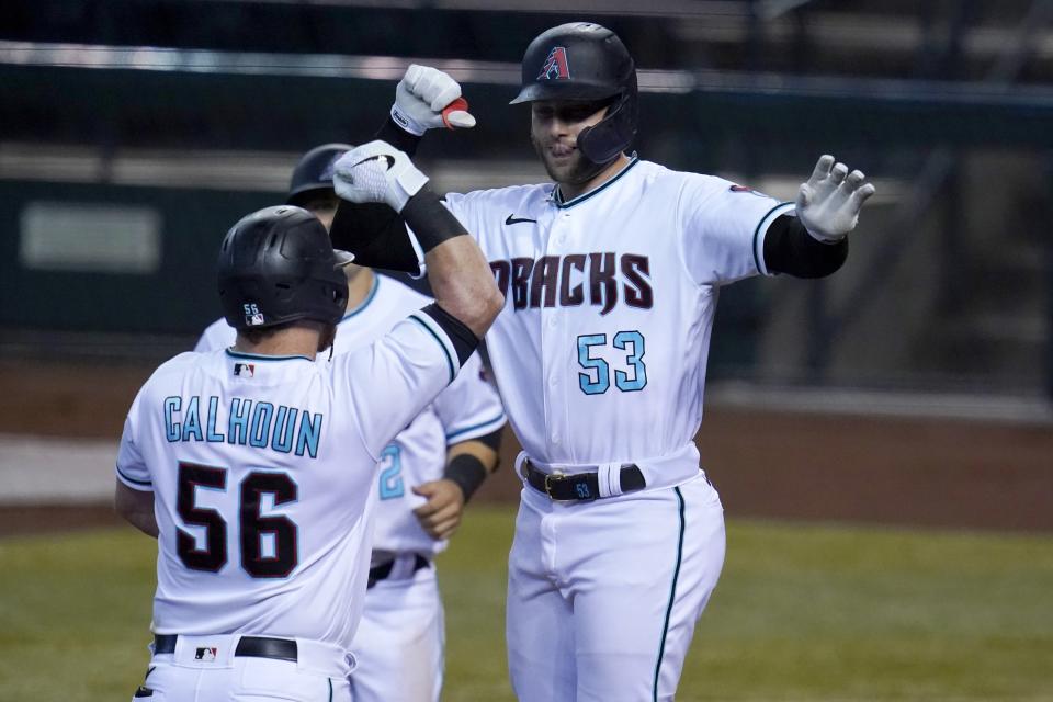 Arizona Diamondbacks' Christian Walker (53) celebrates his two-run home run against the Colorado Rockies with Kole Calhoun (56) and Daulton Varsho during the third inning of the first game of a baseball doubleheader Friday, Sept. 25, 2020, in Phoenix. (AP Photo/Ross D. Franklin)