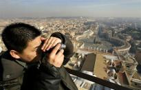 A tourist takes a photograph from the balcony overlooking Saint Peter's square at the Vatican January 18, 2005.