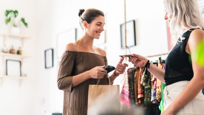 Smiling woman doing credit card purchase.