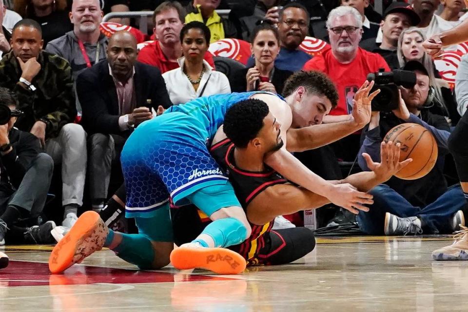 Charlotte Hornets guard LaMelo Ball, top, and Atlanta Hawks guard Timothe Luwawu-Cabarrot go for the ball during the first half of an NBA play-in basketball game Wednesday, April 13, 2022, in Atlanta. (AP Photo/John Bazemore)