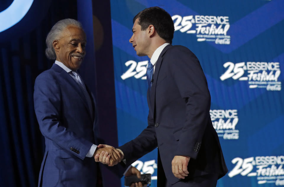 Democratic presidential candidate, and South Bend, Ind. Mayor Pete Buttigieg, shakes hands with the Rev. Al Sharpton, left, as he arrives to speak at the 25th Essence Festival in New Orleans, Sunday, July 7, 2019. (AP Photo/Gerald Herbert)