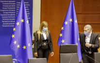 Two employees wear face masks, to prevent against the spread of coronavirus, as they prepare the plenary room at the European Parliament in Brussels, Wednesday, May 27, 2020. The European Union is to unveil Wednesday a massive coronavirus recovery plan worth hundreds of billions of euros to help countries rebuild their ailing economies, but the bloc remains deeply divided over what conditions should be attached to the funds. (AP Photo/Olivier Matthys)