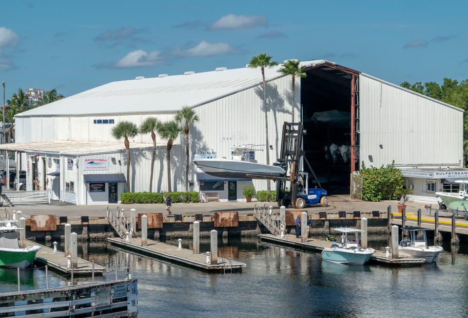 A forklift carries a boat from the indoor boat house to a slip at the PGA Marina in Palm Beach Gardens, Florida on September 25, 2023. 
