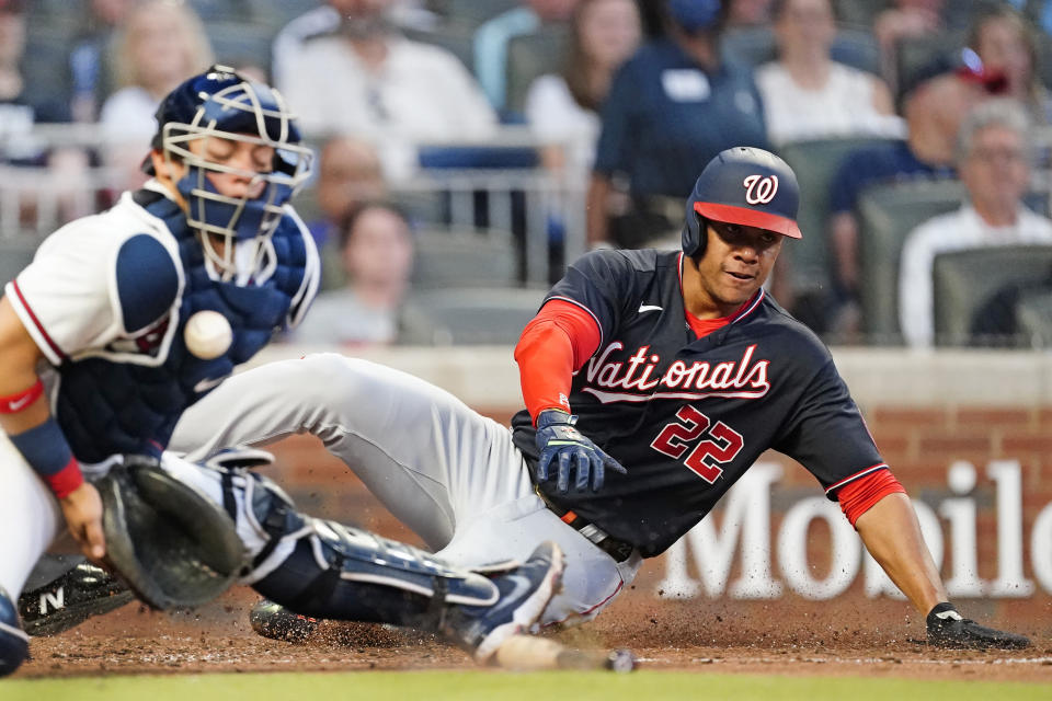 Washington Nationals' Juan Soto, right, scores ahead of the throw to Atlanta Braves catcher William Contreras, left, in the third inning of a baseball game Tuesday, June 1, 2021, in Atlanta. (AP Photo/John Bazemore)