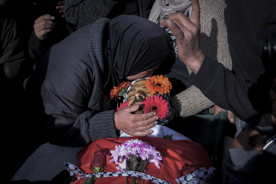 A relative kisses Ahmad Kahla, 45, during his funeral in the West Bank village of Rammun, Sunday, Jan. 15, 2023. The Palestinian Health Ministry says Israeli troops have shot and killed the Palestinian man in the occupied West Bank. The Israeli military said troops opened fire when a passenger in a suspicious vehicle tried to grab a soldier's weapon. (AP Photo/Majdi Mohammed)